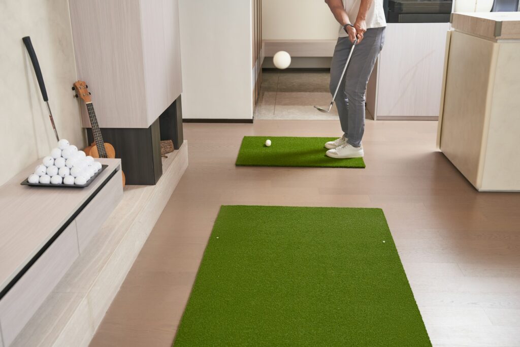 Golfer übt in der Halle das Putten auf einer Putting-Matte